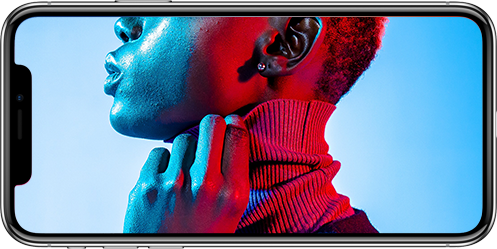 Close-up of a person with a turtleneck, illuminated in blue and red lighting.