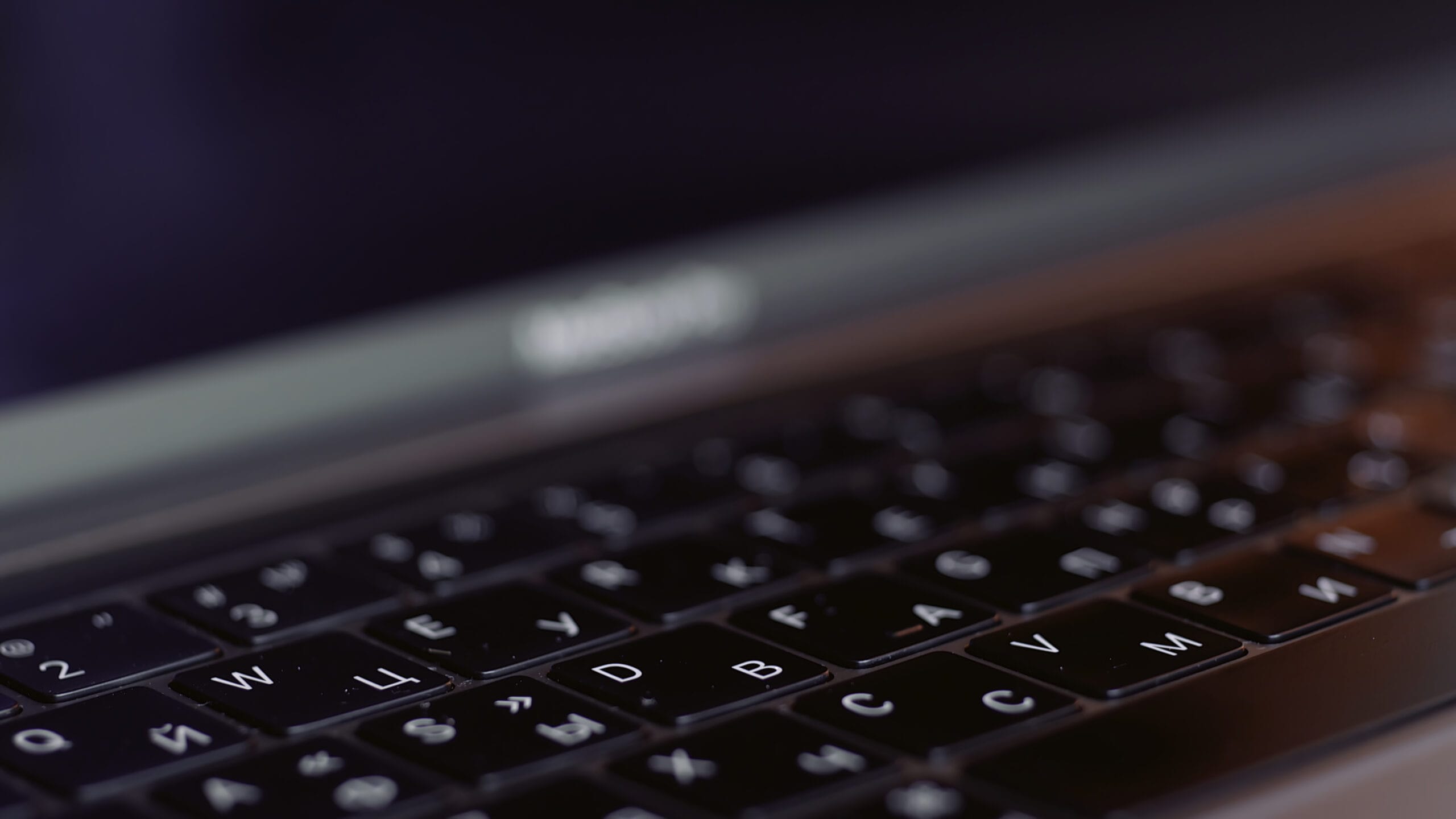 Close-up of a laptop keyboard with Cyrillic letters illuminated.