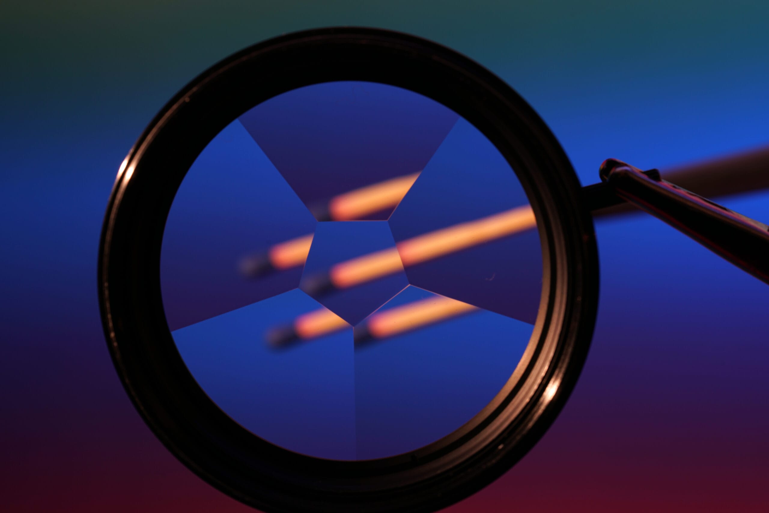 A magnifying lens focusing on three glowing lines against a colorful background.