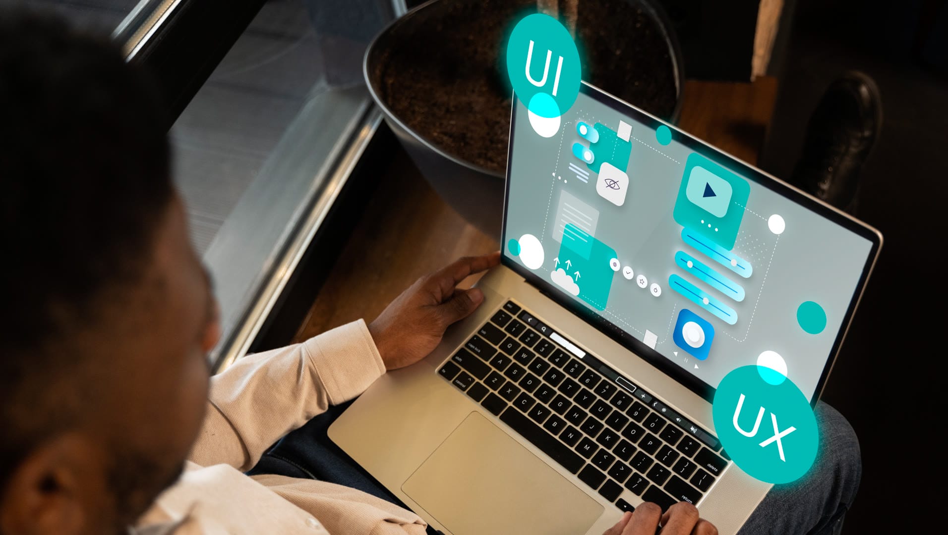 Person working on a laptop displaying UI and UX design elements.