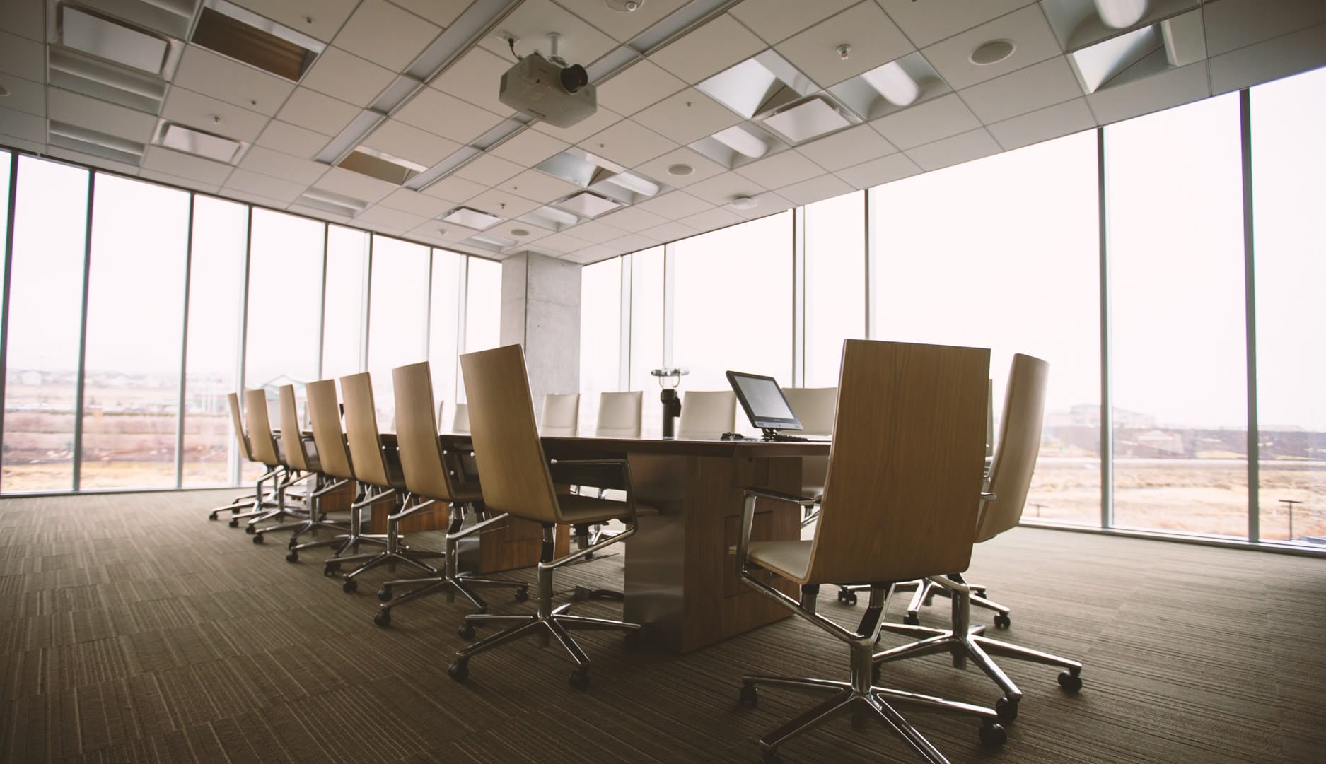 A business meeting in a modern office setting with professionals analyzing data charts on a laptop for optimized business analytics.