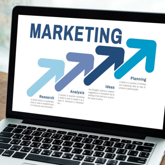 Custom web design display on a laptop screen with Naples, FL beach background