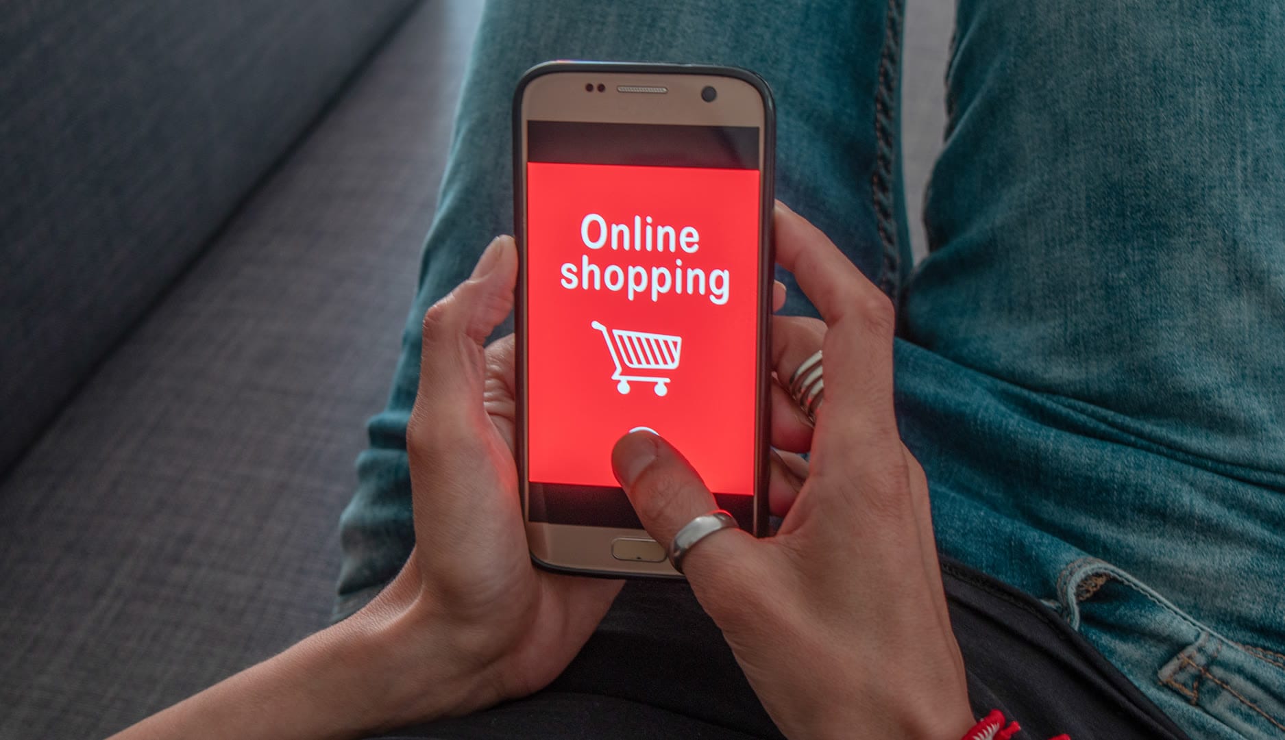 A person holding a smartphone displaying an online shopping screen.