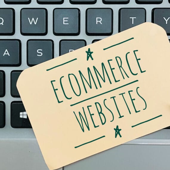 A note reading 'Ecommerce Websites' placed on a laptop keyboard.