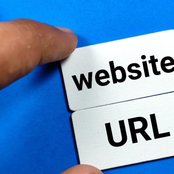 A hand placing cards labeled 'website' and 'URL' on a blue background.
