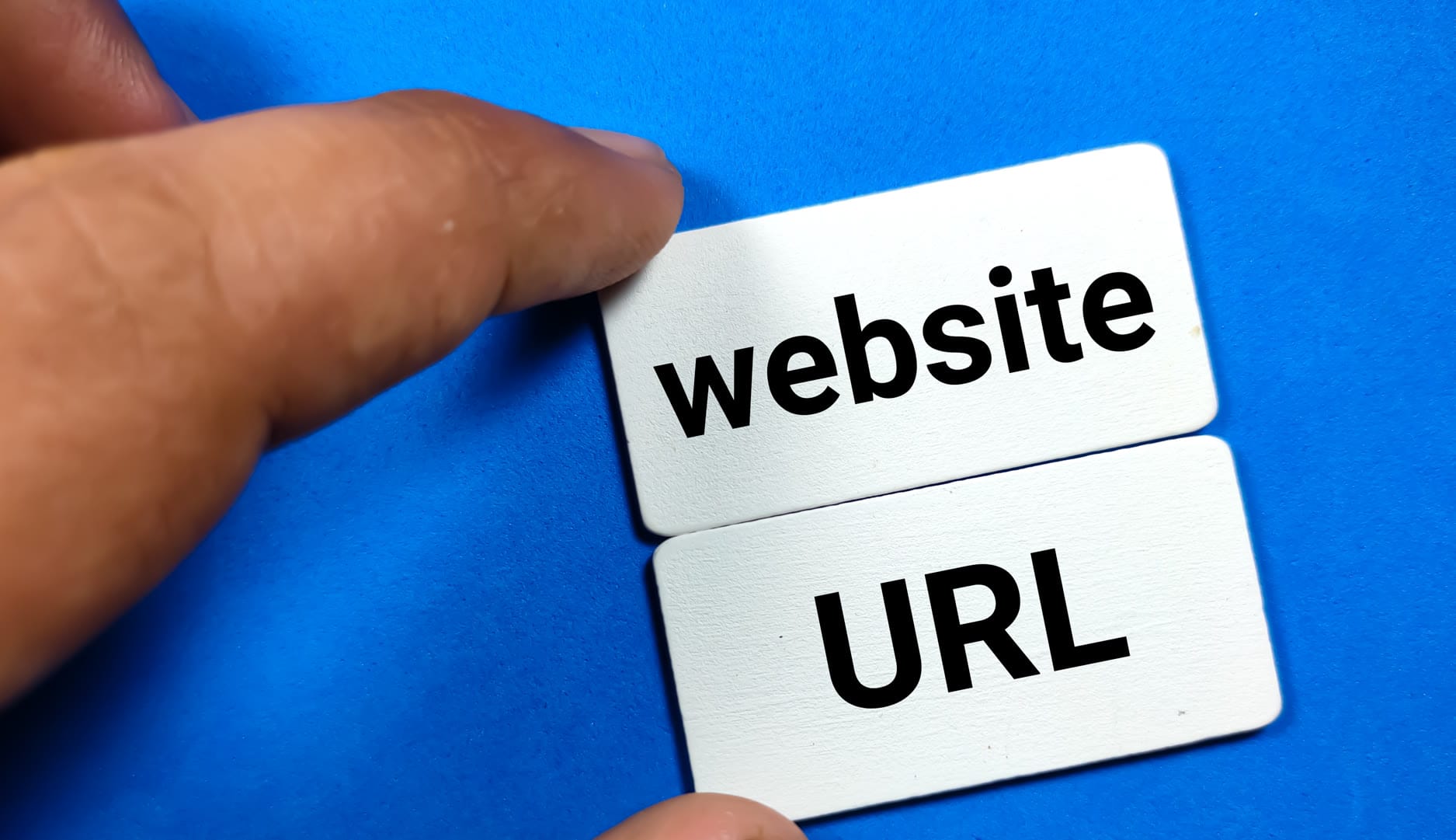 A hand placing cards labeled 'website' and 'URL' on a blue background.