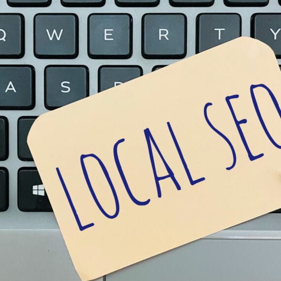 A note with 'LOCAL SEO' written on it placed on a laptop keyboard.