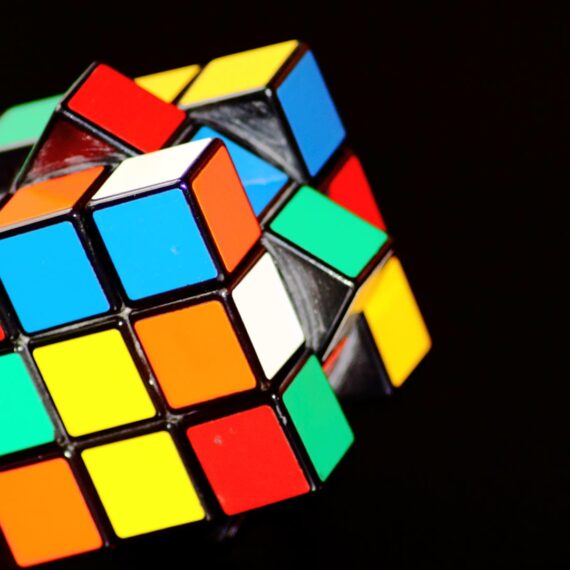 A partially solved Rubik's Cube with vibrant colors against a dark background.