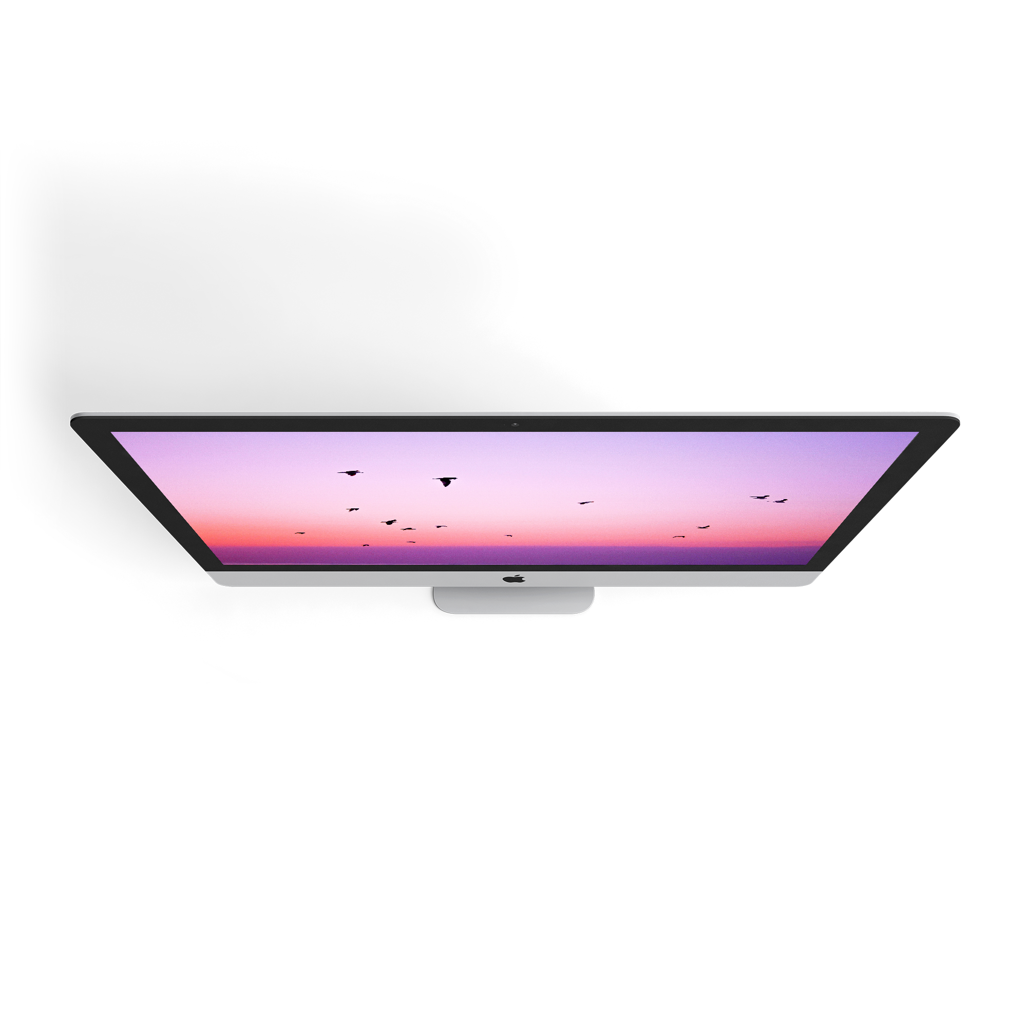 A sleek Apple computer displaying a gradient sunset with flying birds.